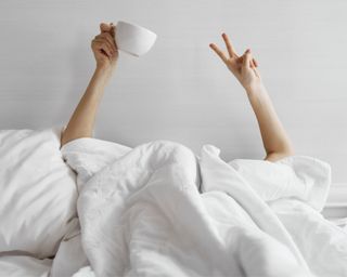 Hands peace sign and coffee out of bed