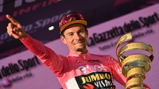 Jumbo-Visma's Slovenian rider Primoz Roglic celebrates on the podium with the race's winner's "Trofeo Senza Fine" (Endless Trophy) after winning the Giro d'Italia cycling race in Rome (Photo by ALBERTO PIZZOLI/AFP via Getty Images)