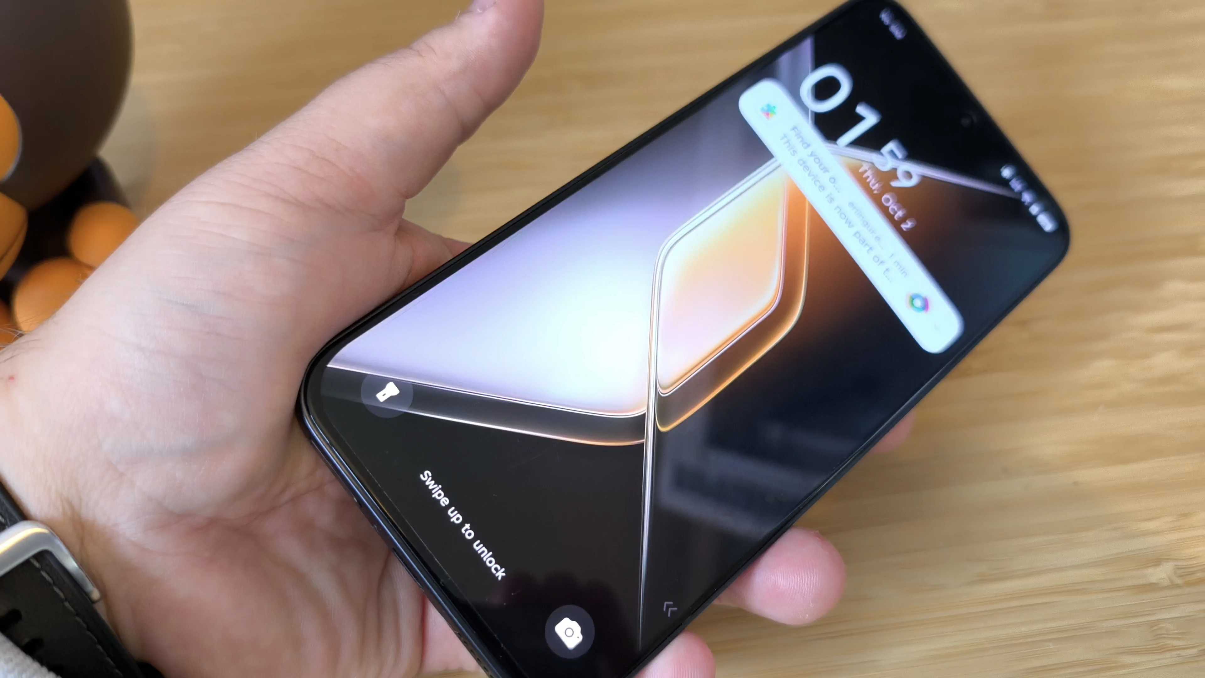 A black Infinix GT 30 Pro phone on a wooden desk