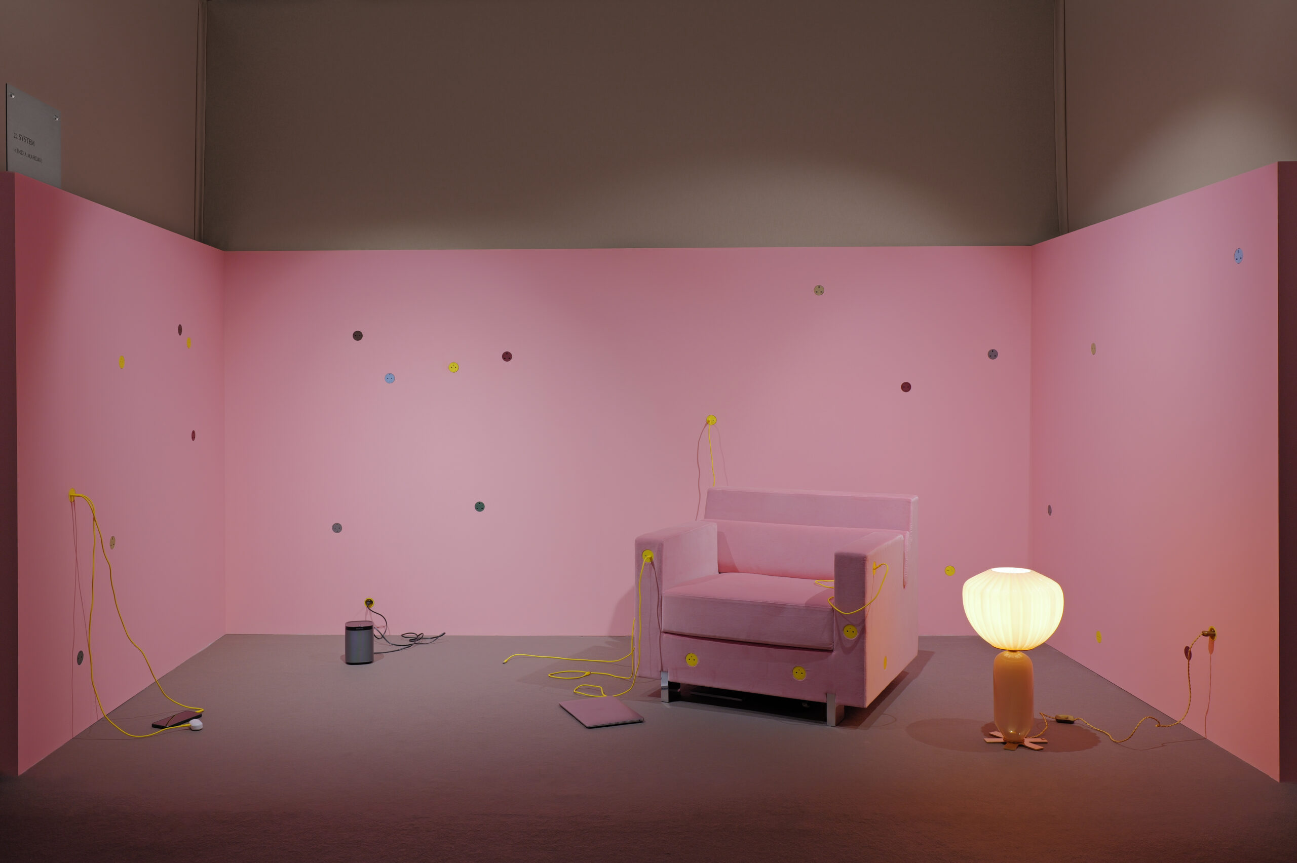 22 System ft. India Mahdavi booth at MATTER and SHAPE shows a pink-painted room dotted in colorful pois, a sculptural, vintage armchair in the same color, and a warm standing lamp.