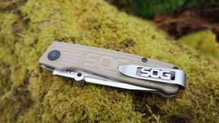 SOG Terminus Slipjoint Satin camping knife folded on mossy log