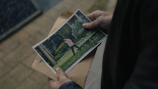 Danny holding the photos of Olly in The Couple Next Door episode 4