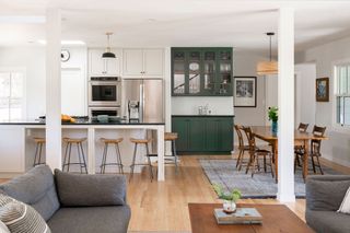 A white open plan kitchen with island bar stools