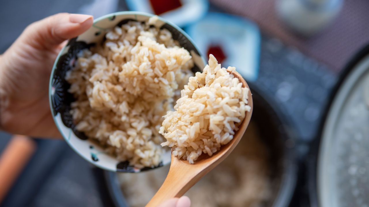 how to store rice: woman holding a bowl of rice 