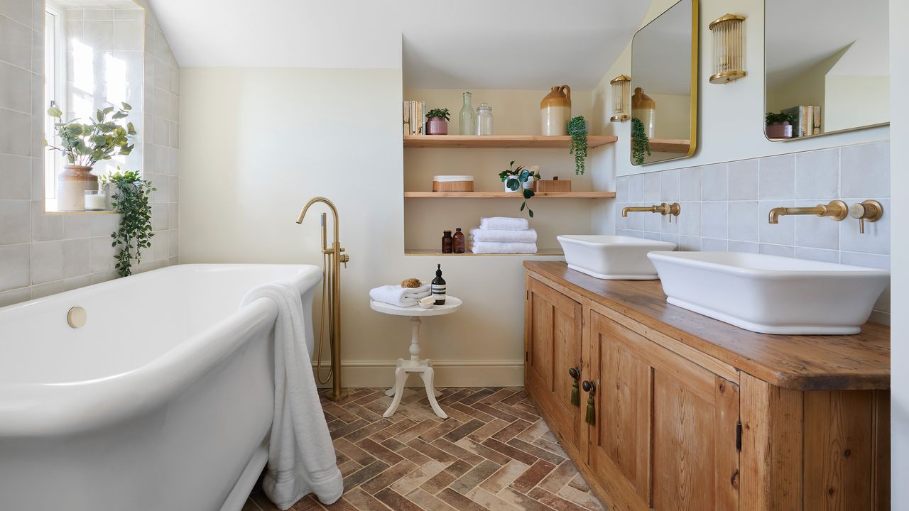 bathroom large traditional bath tub, twin basin vanity unit, mirror, open shelving, and terracotta floor tiles