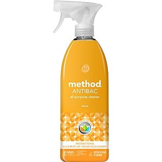 A side-on view of an orange bottle of Method Antibacterial All-Purpose Cleaner Spray with white spray lid