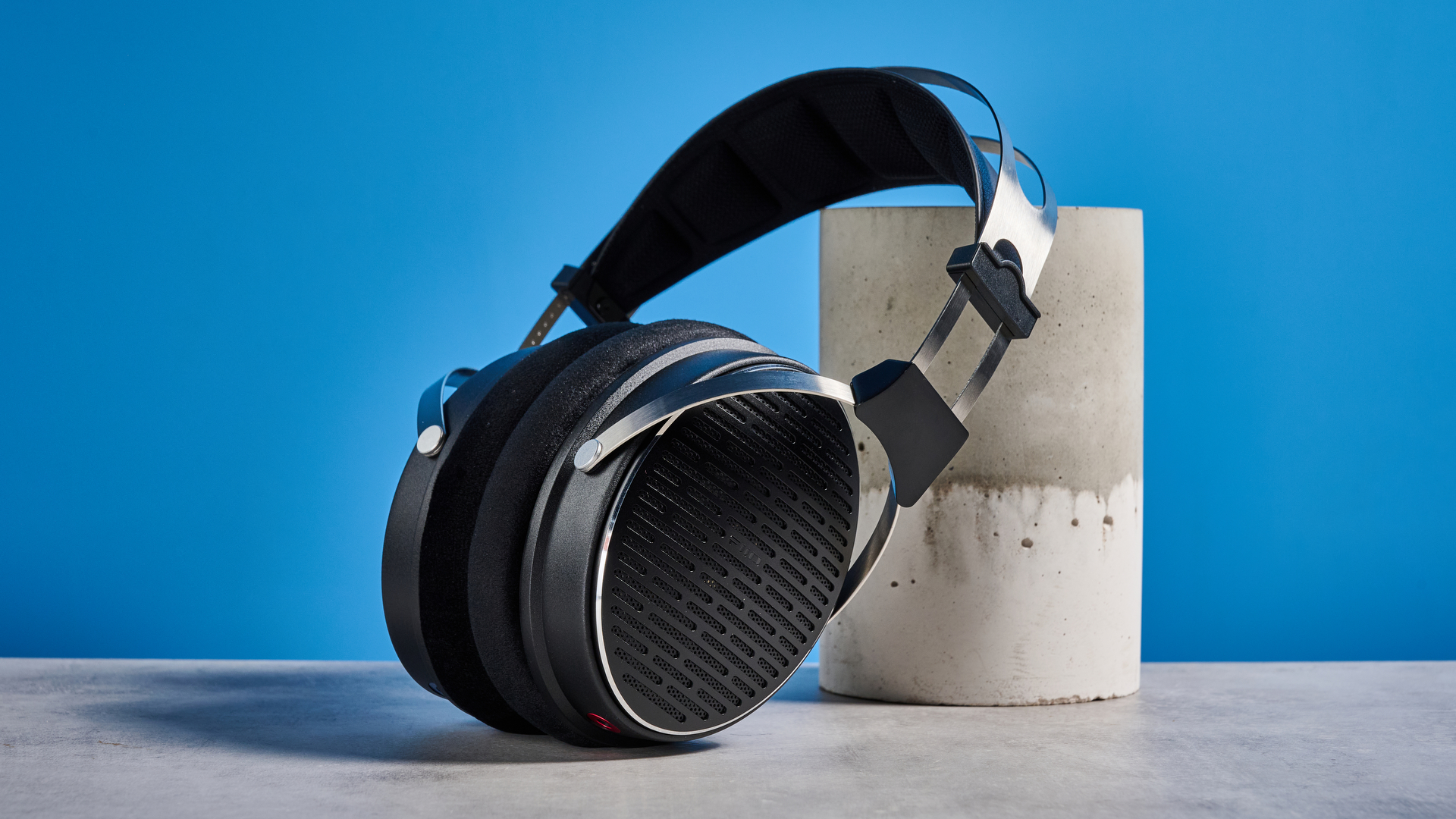 the FiiO JT3 headphones in black and silver shown against a blue tom's guide background