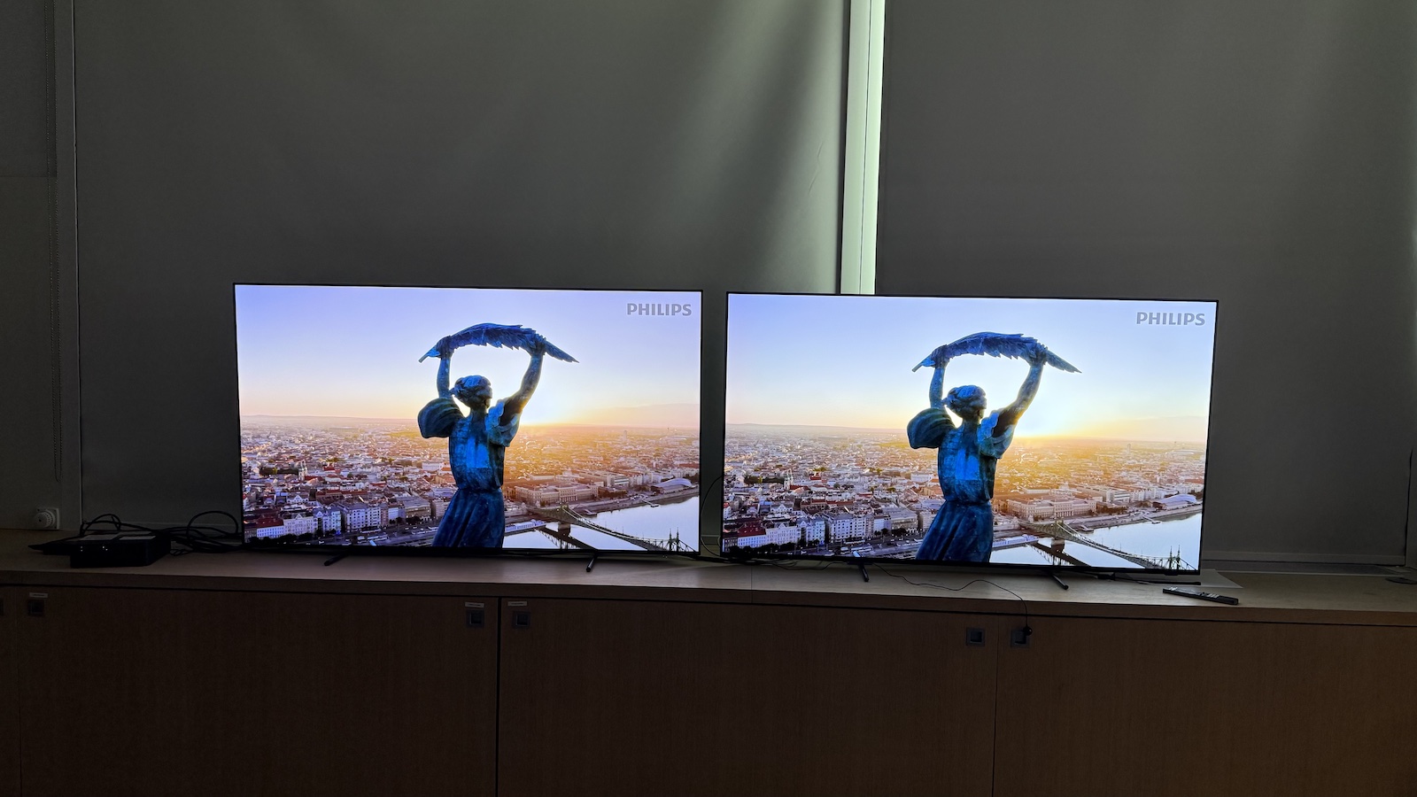 The 65-inch Philips OLED951 TV pictured alongside the 65-inch Philips OLED950. On both screens is the same scenery shot.