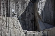 A stone chair by Max Lamb camouflaged on the rocks of a stone quarry in Northern Italy