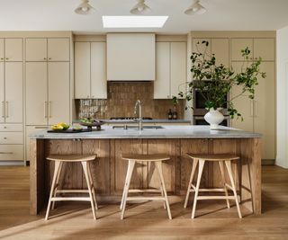 kitchen with cream cabinetry and wooden island and bar stools