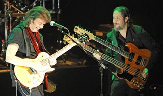 Lee (right) wields a double-neck onstage with Steve Hackett