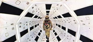 Screenshot from 2001: A Space Odyssey of a astronaut walking through the space station.