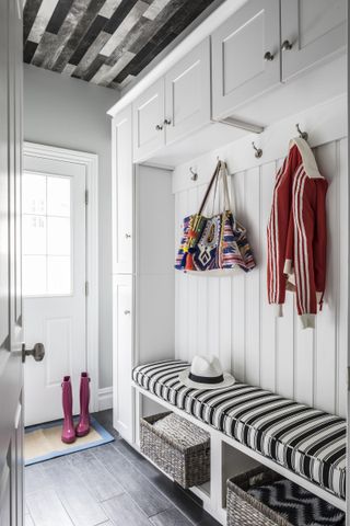 entryway with stripe bench and bespoke cabinetry painted white