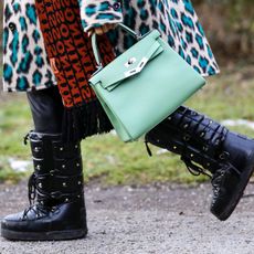mint green bag by Hermes and black vintage snow boots by Valentino as a detail of influencer and TV host Cathy Hummels during a street style shooting on January 24, 2021 in Munich, Germany