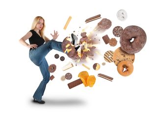 A woman kicks many unhealthy foods away from herself