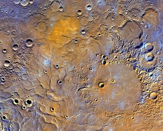 This enhanced map of Mercury's northern pole exaggerates the colors to reveal insights about the different types of rocks on the planet's surface. The 181-mile-wide (291 kilometers) Mendelssohn impact basin shown at the bottom right may have once been nearly filled with lava. The bright orange region at the top shows the location of a newly identified volcanic vent.