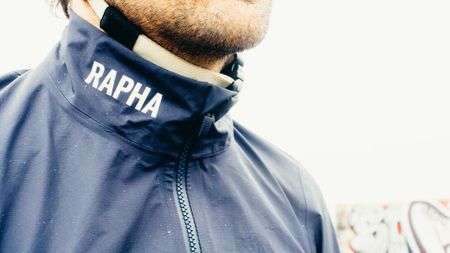 A close up of the collar of a blue Rapha waterproof cycling jacket