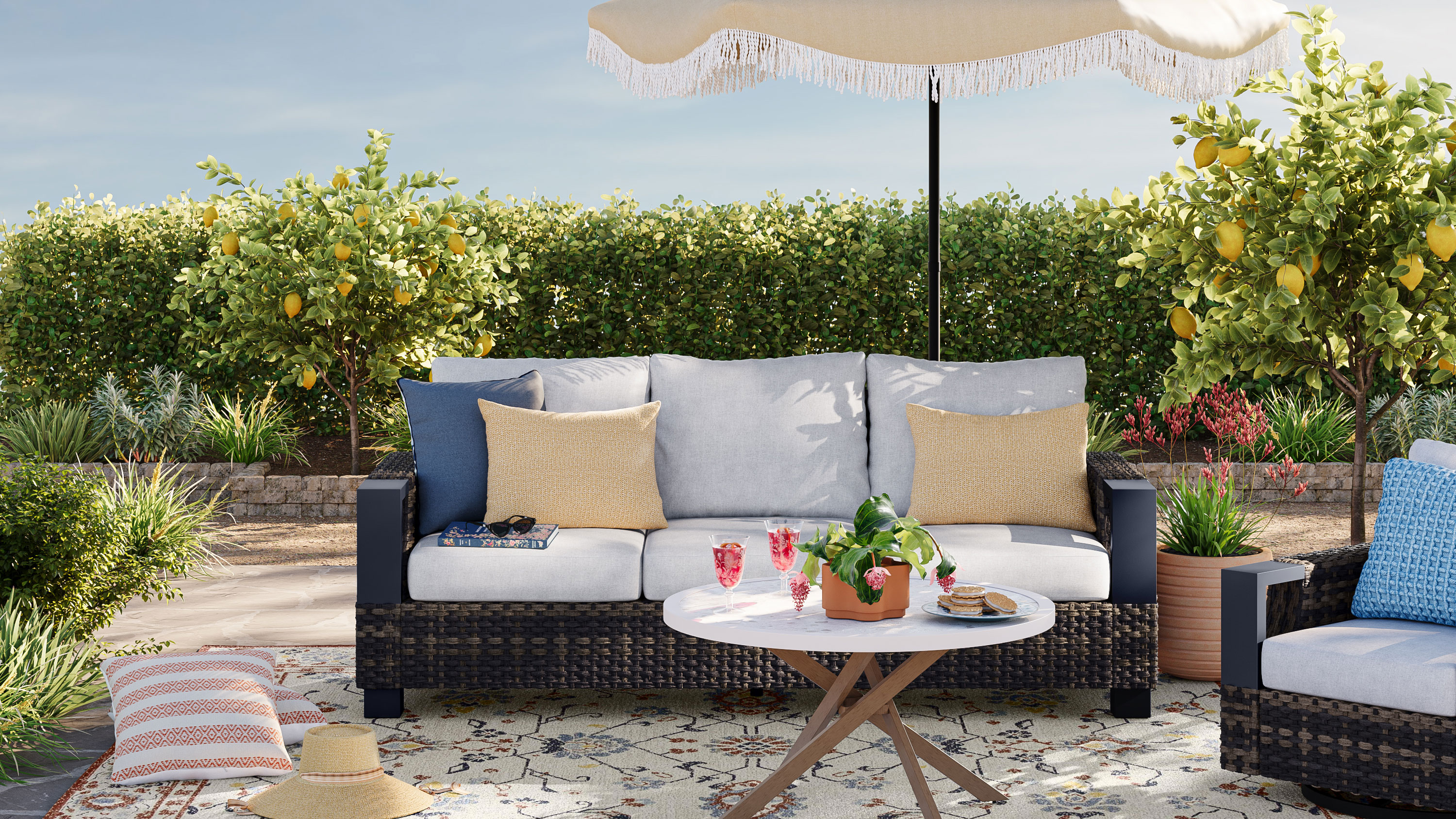 Garden patio with woven seating and round coffee table with parasol and throw pillows