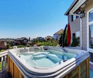 A hot tub in a backyard with a view of other houses