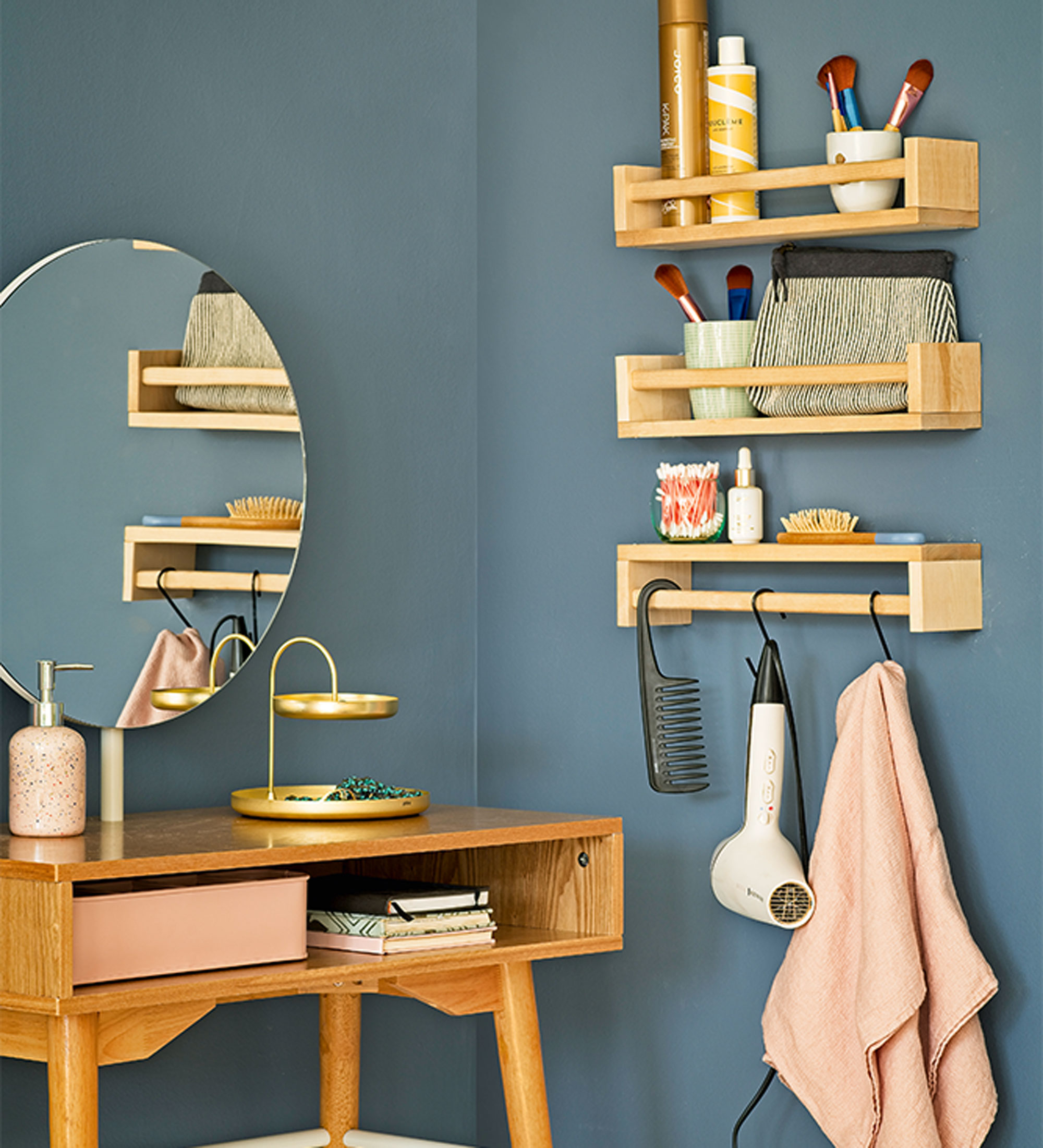 Blue bedroom with wooden dressing table, shelving for make up and products