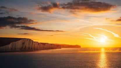the Seven Sisters cliffs with the sun in the background by Benjamin Davies