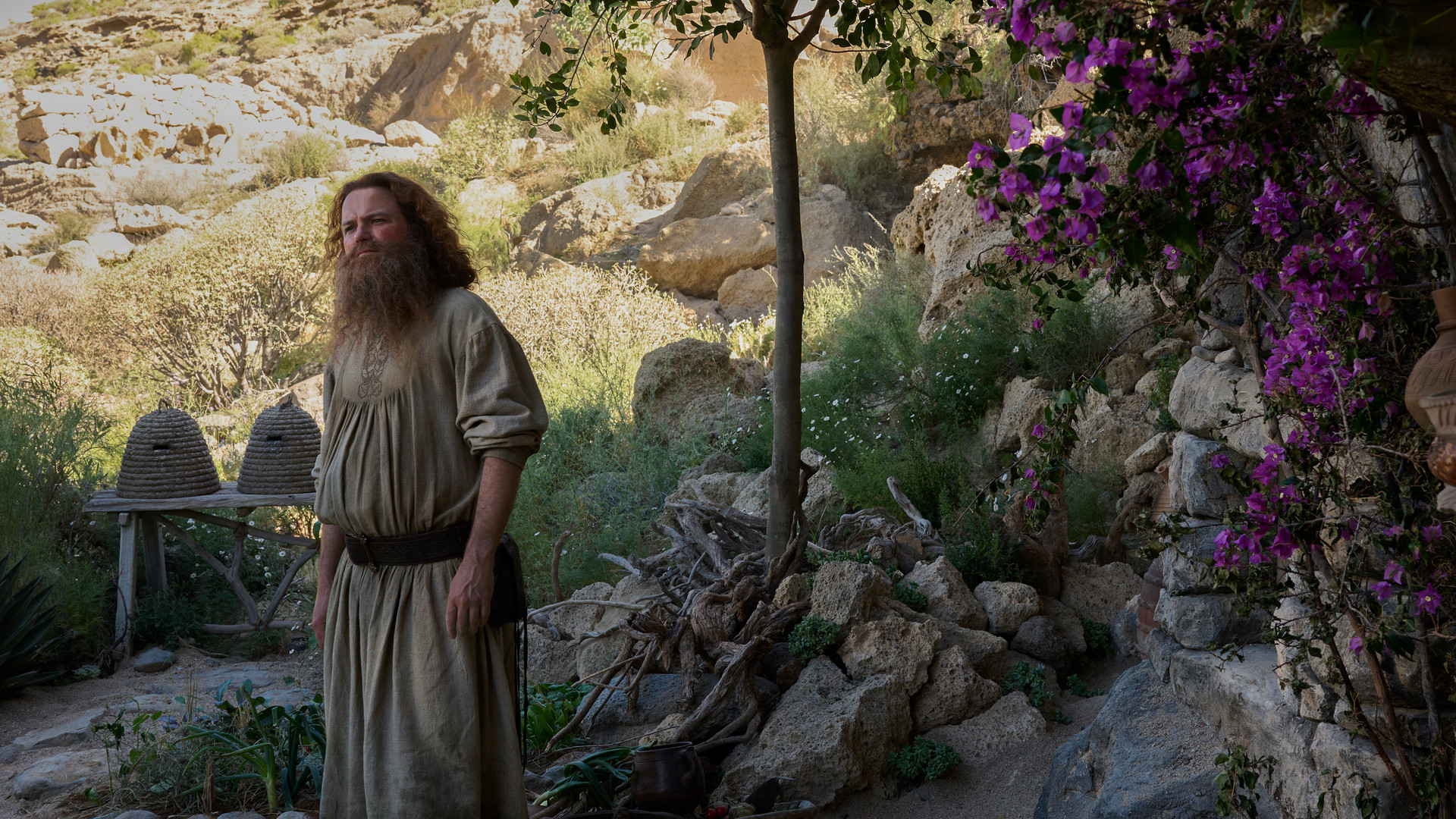 Rory Kinnear as Tom Bombadil in front of his hut in The Rings of Power.