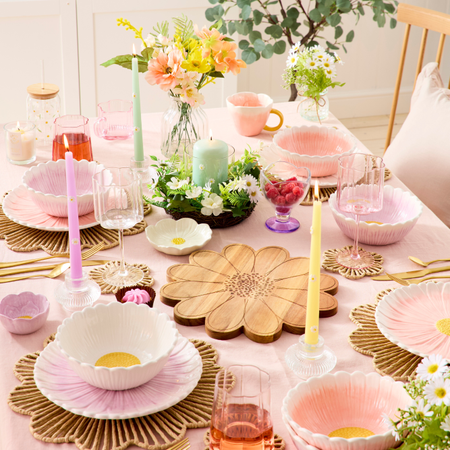 Daisy-themed decor on a pink tablecloth.