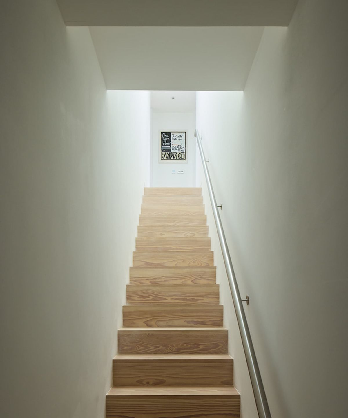 A wooden staircase with a metal handrail