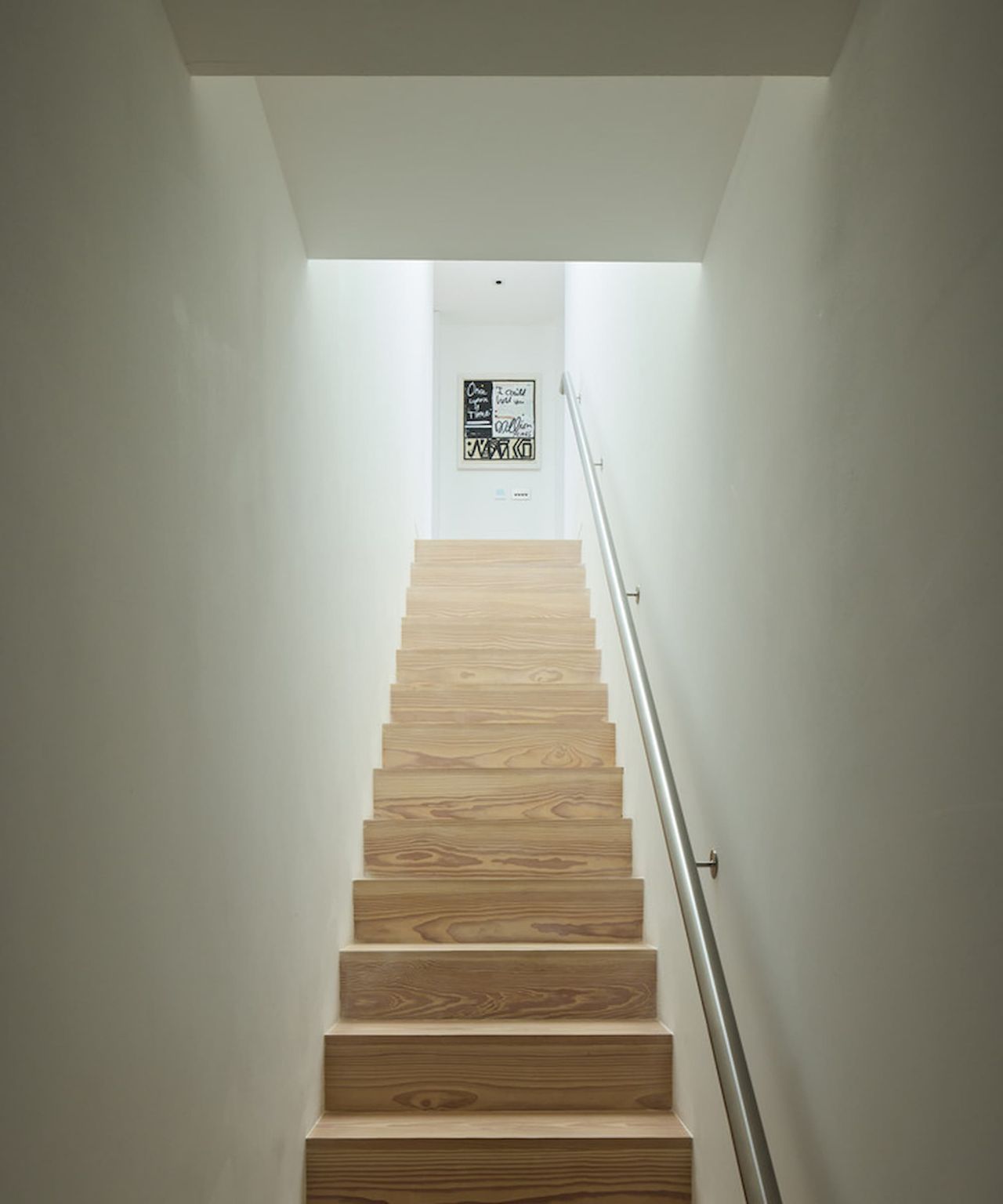 A wooden staircase with a metal handrail