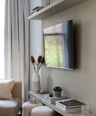 tv on the wall of neutral living room