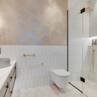 bathroom with designed wall commode glass shower cabin and hexagonal design flooring
