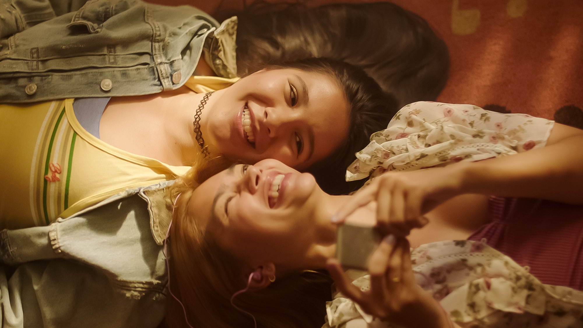 Myra Molloy stars as Sonya and Maya Da Costa as Coley laying together while smiling in director Hayley Kiyoko&amp;rsquo;s GIRLS LIKE GIRLS