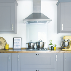  Grey kitchen units with wooden worktop and white walls. A renovated four bedroom semi detached house in Suffolk, home of Jessica and Michael West.