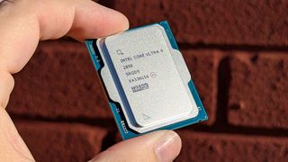 Intel Core Ultra 9 285K processor held in front of a red brick wall