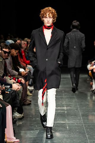 Model wore black coat and white pant
