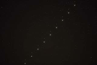 a series of nine images of jupiter and mars conjunction put together in one composition image shows the two points of light travelling up together through the sky, there are some smaller bright points of light close to Jupiter, these are some of the planet's moons.