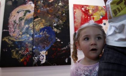 Not-your-average-toddler, Australian Aelita Andre poses in front of her abstract paintings, some of which have sold for tens of thousands of dollars.
