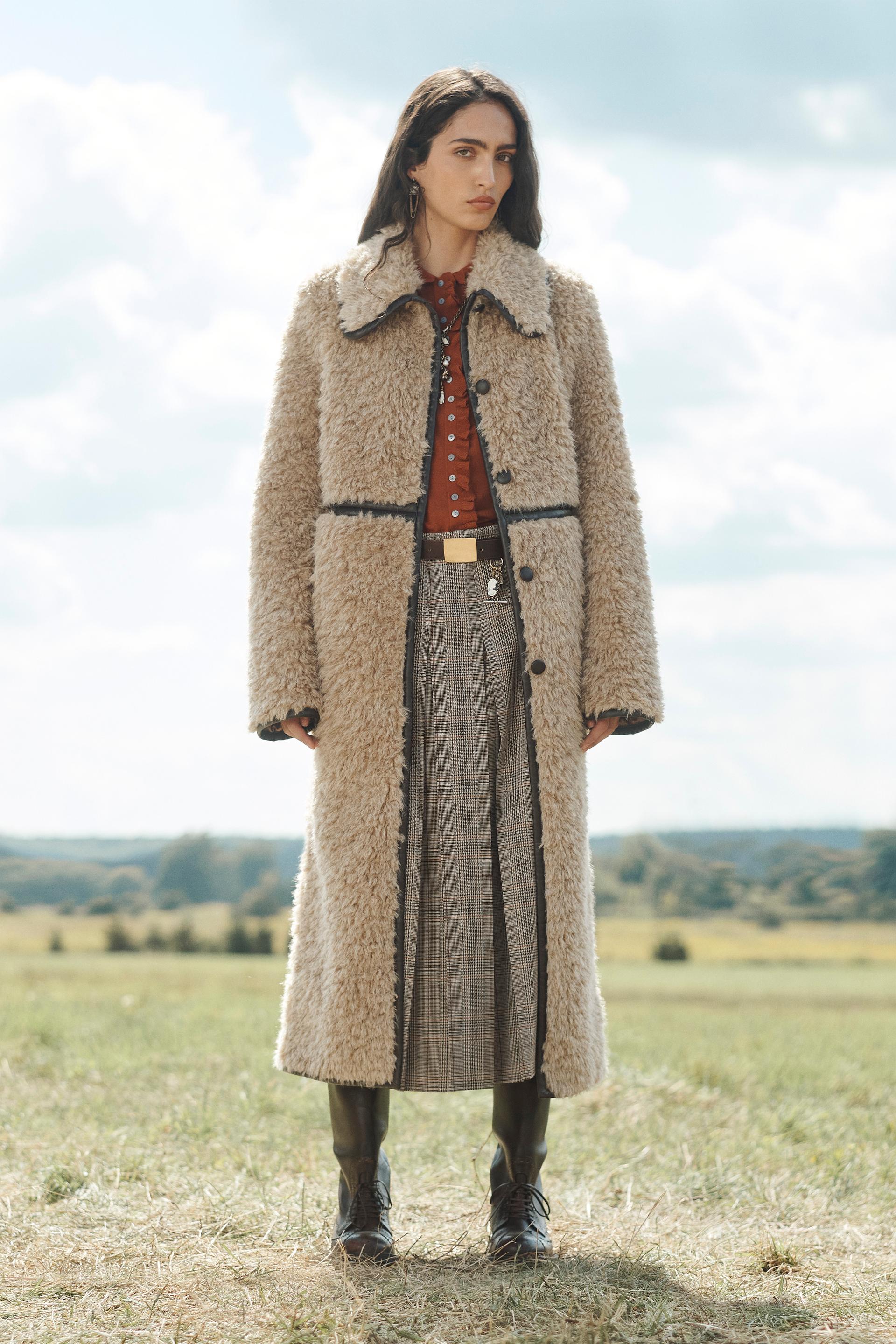 Model wears Zara winter coat trends. She wears a maxi shearling coat.