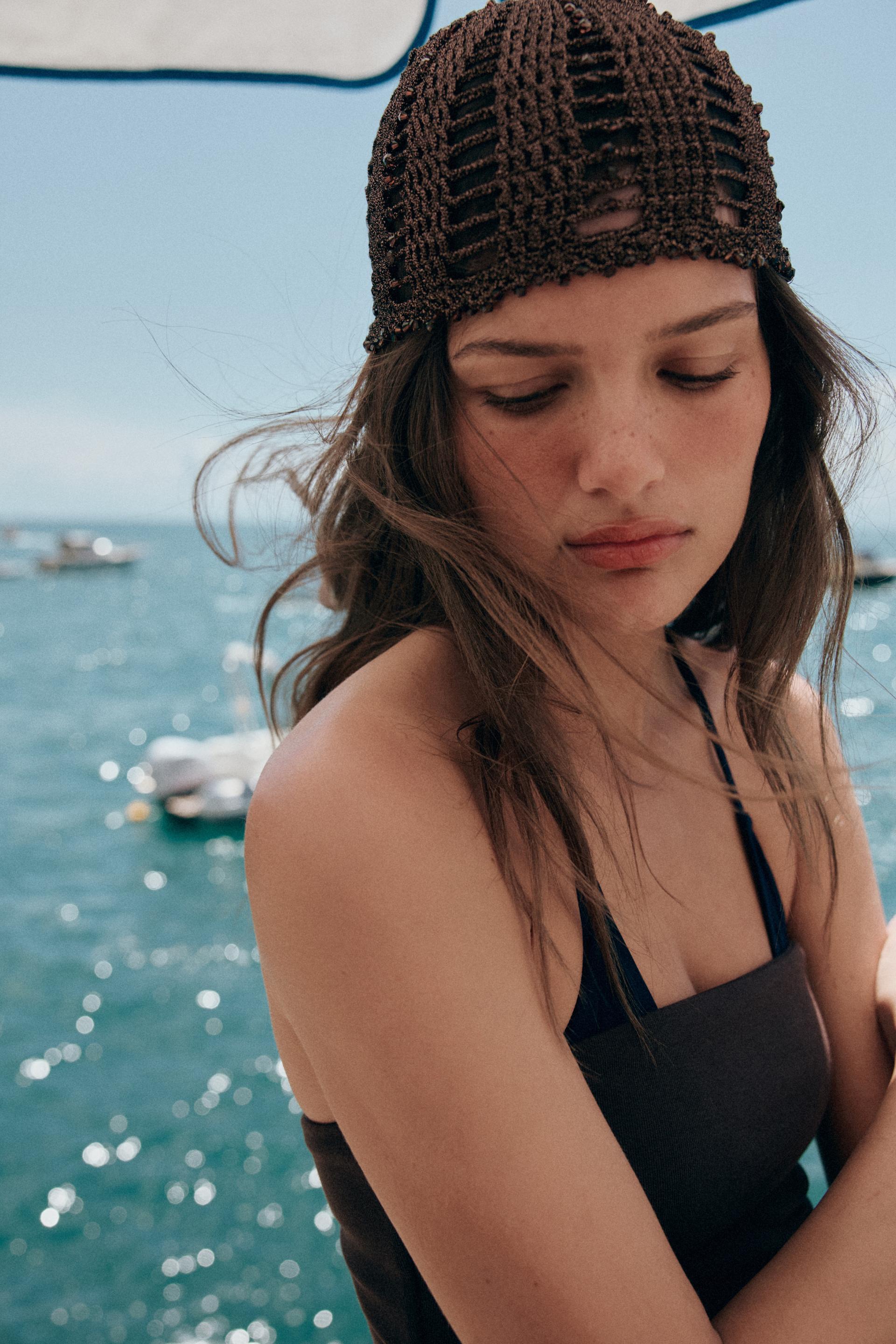 woman wears dark brown crocheted skull cap