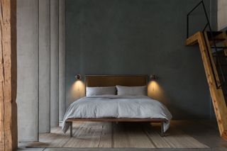 A grey themed bedroom with a roman clay painted wall and wooden architectural features