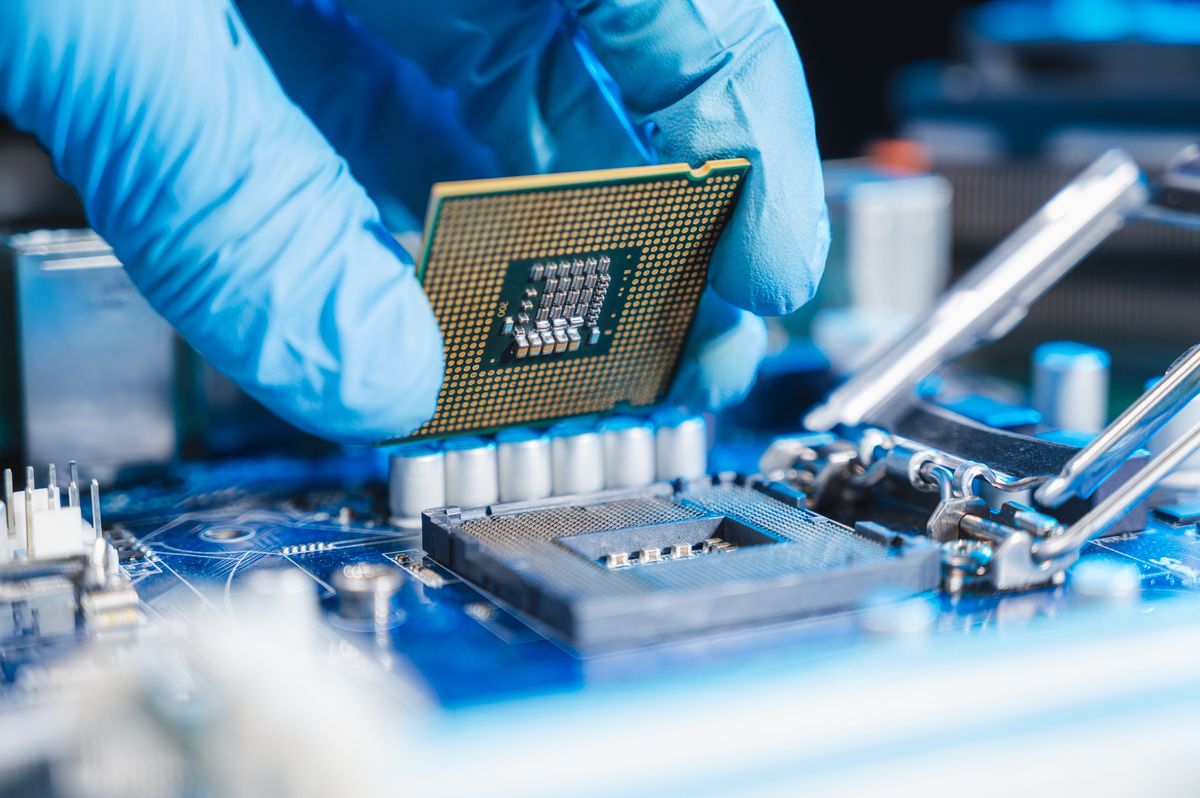 A technician laying CPU in the motherboard socket 