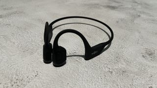 Shokz OpenRun Pro bone conduction sports headphones on a concrete surface