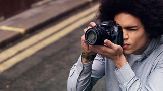 De bedste spejlreflekskameraer - ung mand er ved at tage et billede med et Canon kamera