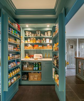A pantry with teal interior and doors, and a sink and breakfast area