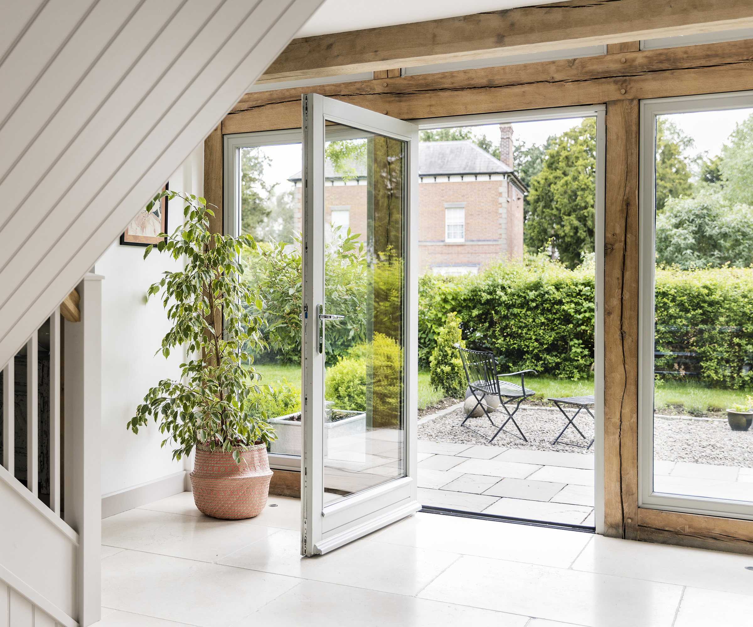 Large glass door framed in oak which opens out onto a patio