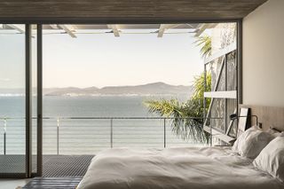 bridget house, a residence open towards sea views via glazed facade and metal structure framing the openings out to the sea