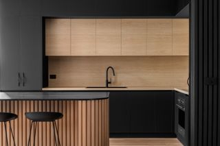 A kitchen with a black island countertop