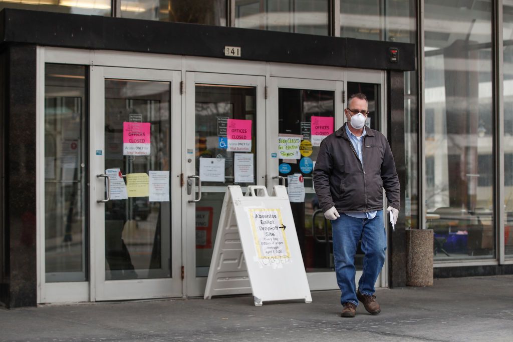 A Wisconsin voter wears a mask as he tries to drop off his ballot.