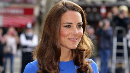 Kate Middleton wearing a fitted blue dress.