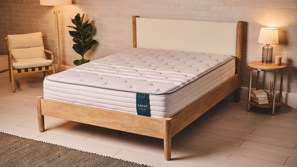 The Leesa Studio Chill mattress placed on a simple bedframe in a well-lit bedroom with neutral shades